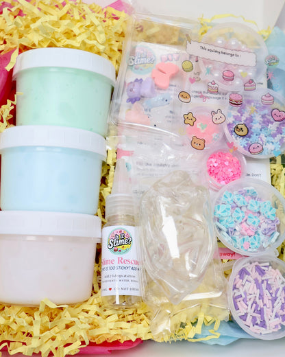 Deluxe squishy kit contents with three slimes, three skins, glitter, mix-ins, charms and stickers